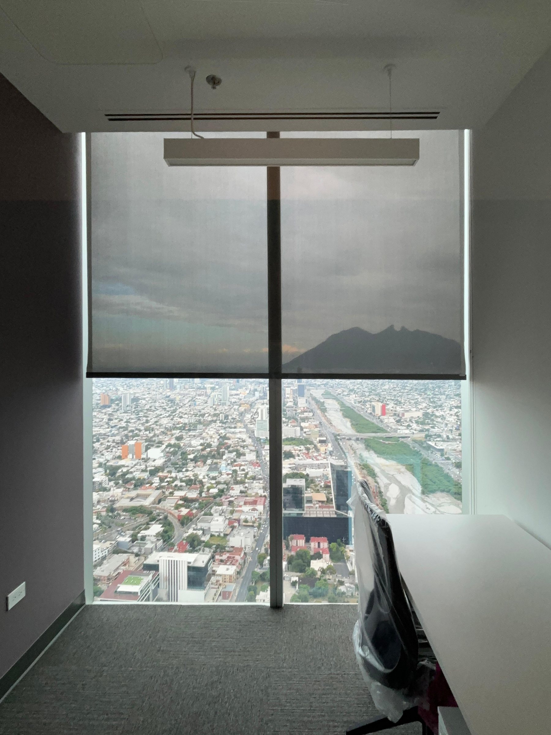 Oficinas Mirador — persiana screen motorizada frente a la vista de Monterrey